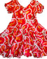 A red ruffled dress  laid flat on white floor featuring a white chain pattern with football and KC graphics