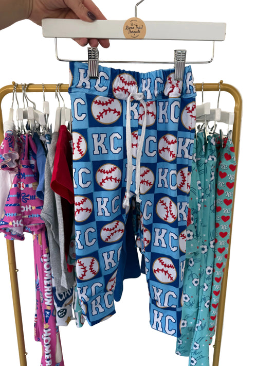 Folded fabric with 'KC' and baseball designs on a rack.
