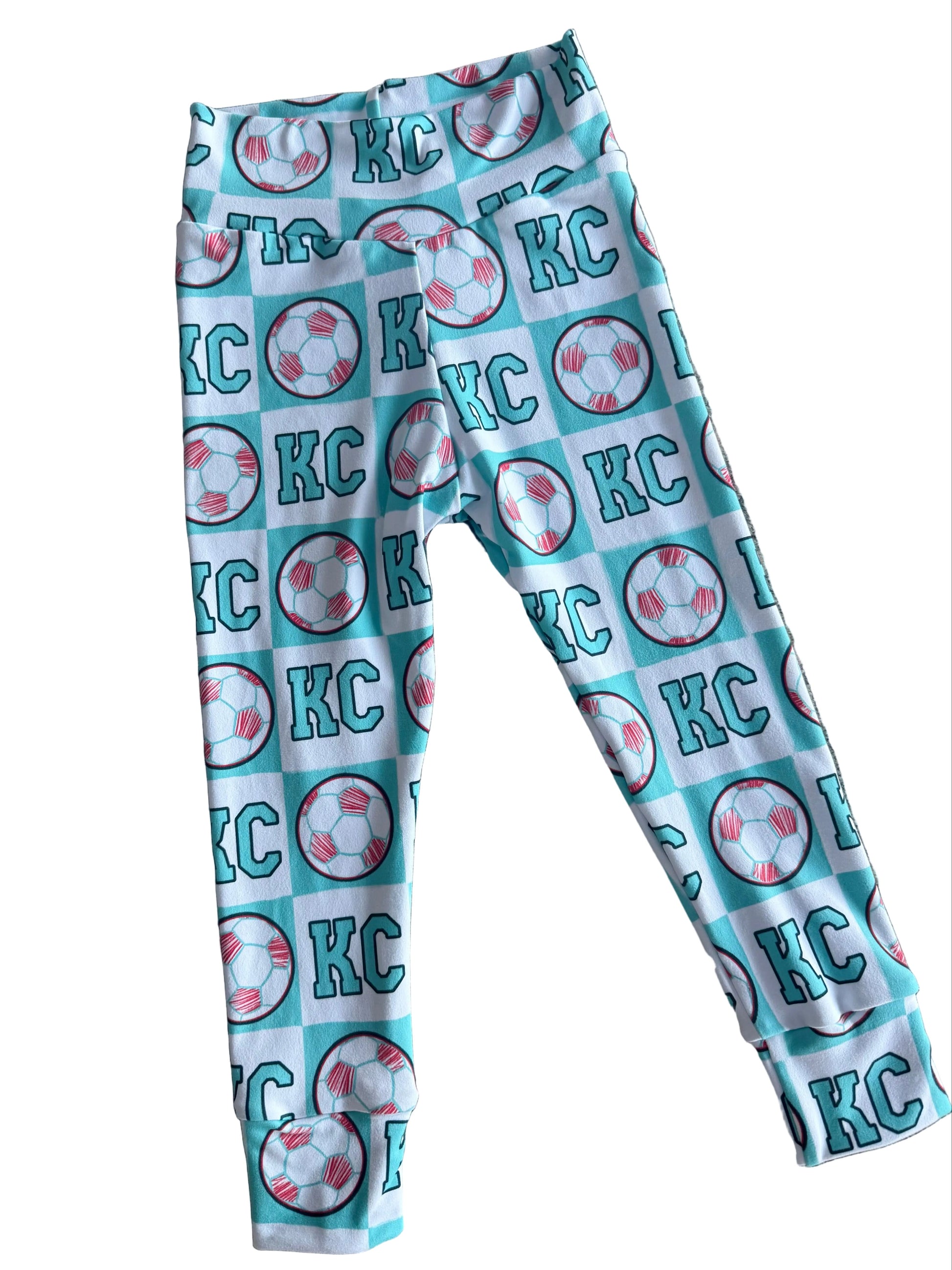 Leggings with 'KC' pattern on a textured surface