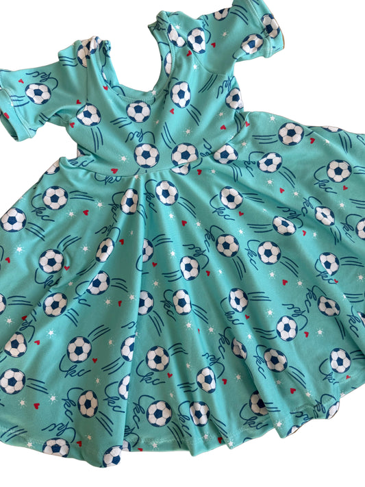 Teal fabric with soccer ball pattern on a wooden surface