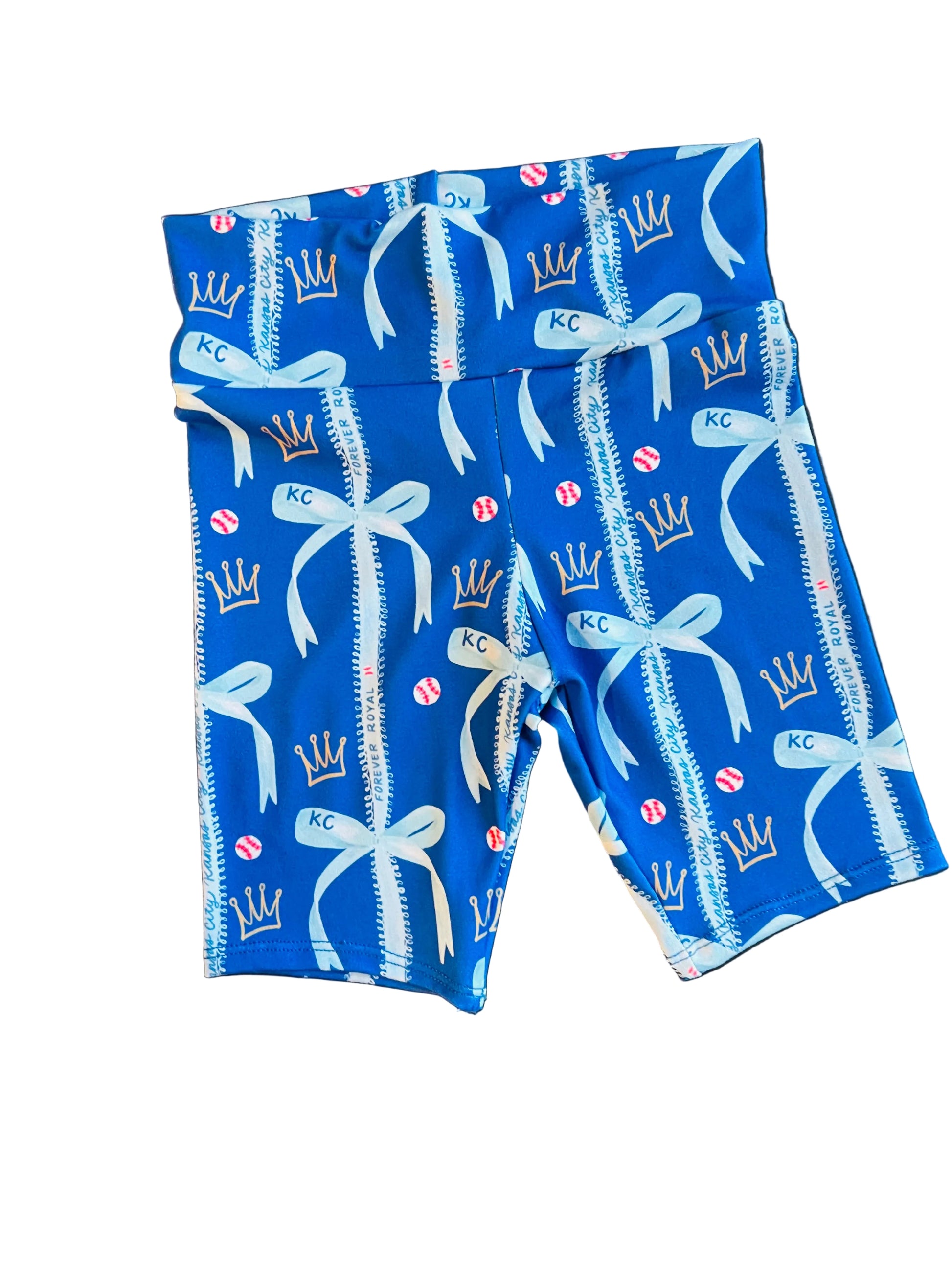 Blue patterned fabric with white bows and 'KC' branding on a dark surface